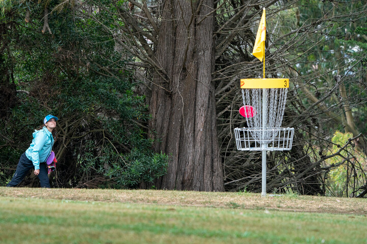 Disc golfer making a long putt