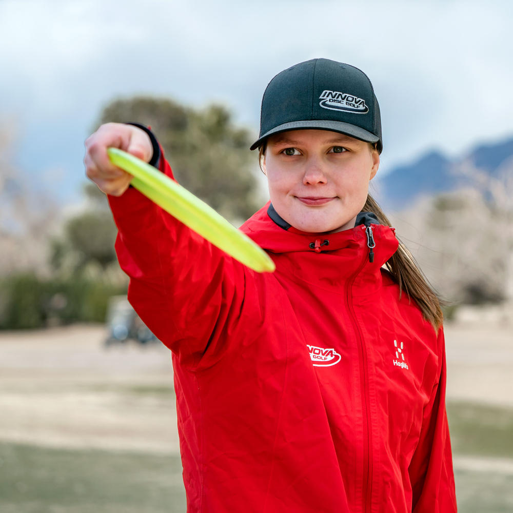 Disc golfer Henna Blomroos lining up a shot with a large diameter mid range shot.